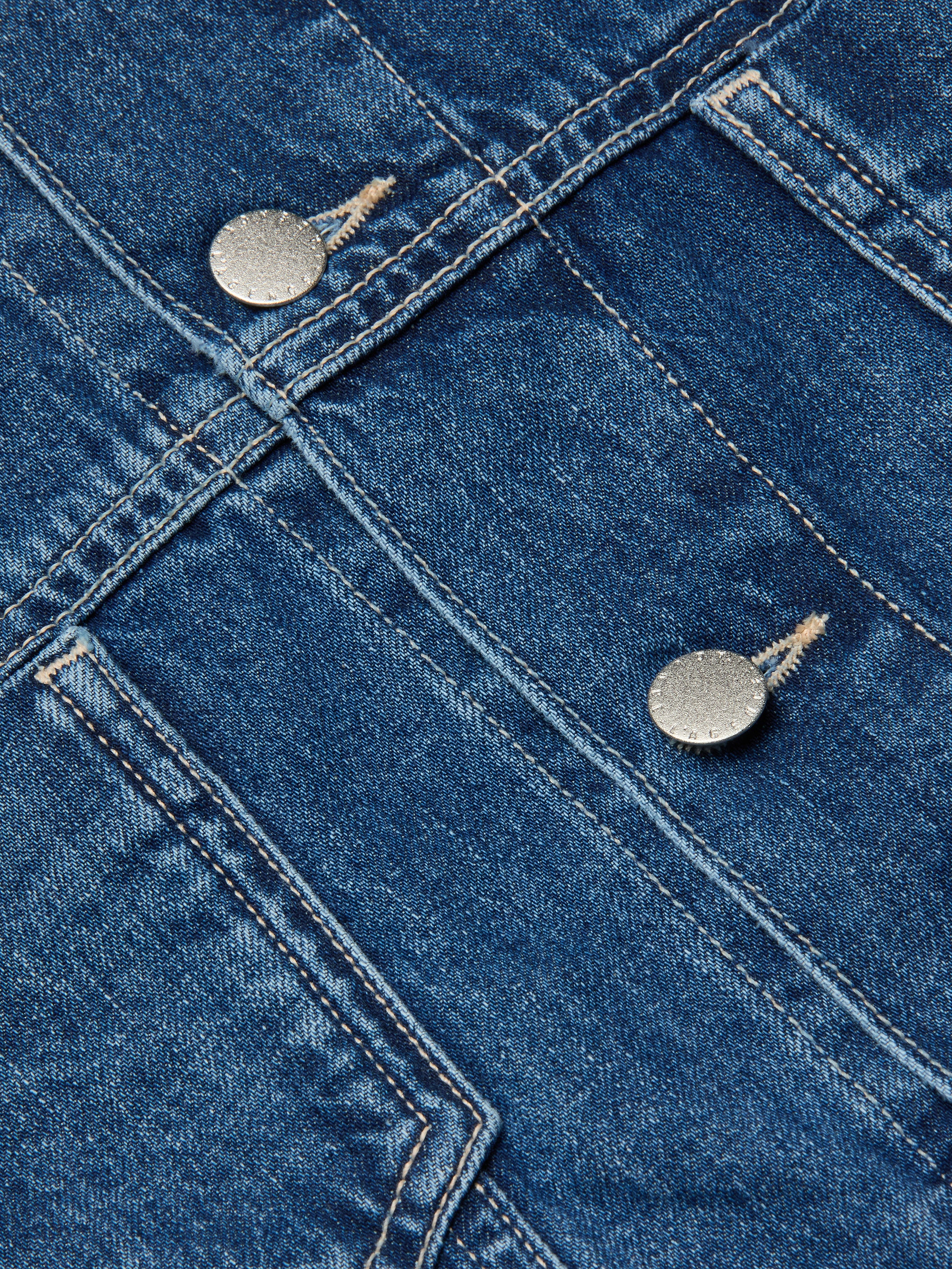 Close-up of the Silas Cape Jacket in blue all-cotton denim, featuring double seams and two metallic buttons that highlight the textured fabric and precise stitching details typical of this jean shirt jacket.
