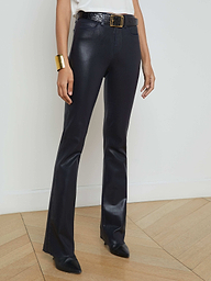 A person wearing the Ruth Coated Straight-Leg Jean with a belt and black shoes, paired with a white top and gold bracelet, stands against a plain light background.
