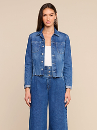 A woman wearing the Janelle Jean Jacket with a frayed hem and wide-leg jeans stands against a plain light background, facing forward with a neutral expression.