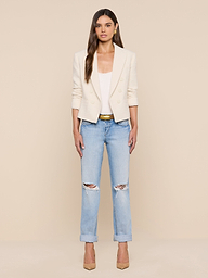 A woman stands facing forward, wearing the Brooke Tweed Blazer in white, paired with a white top, ripped light blue jeans, and beige heels against a plain white background.