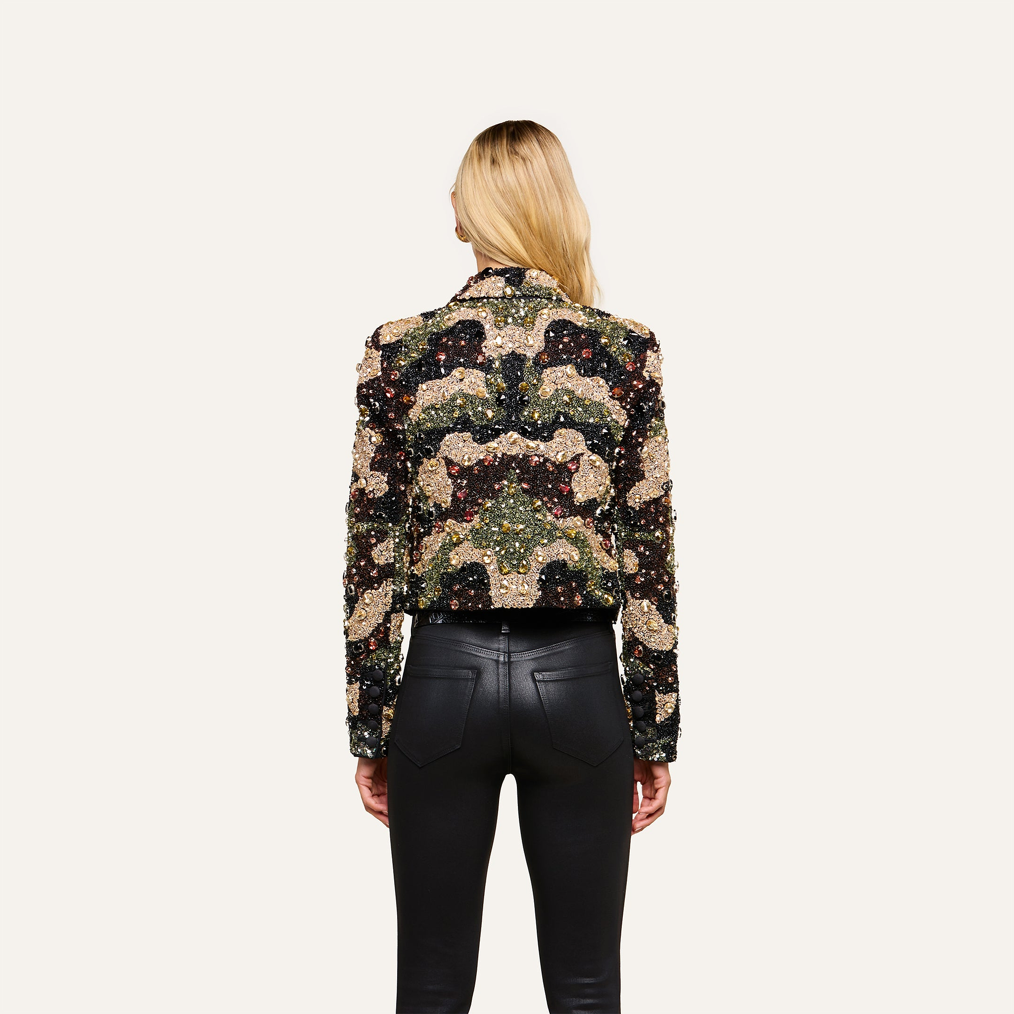 A woman with long blonde hair, seen from behind, wears the Jen Crystal Blazer and black leather pants, standing against a plain off-white background.