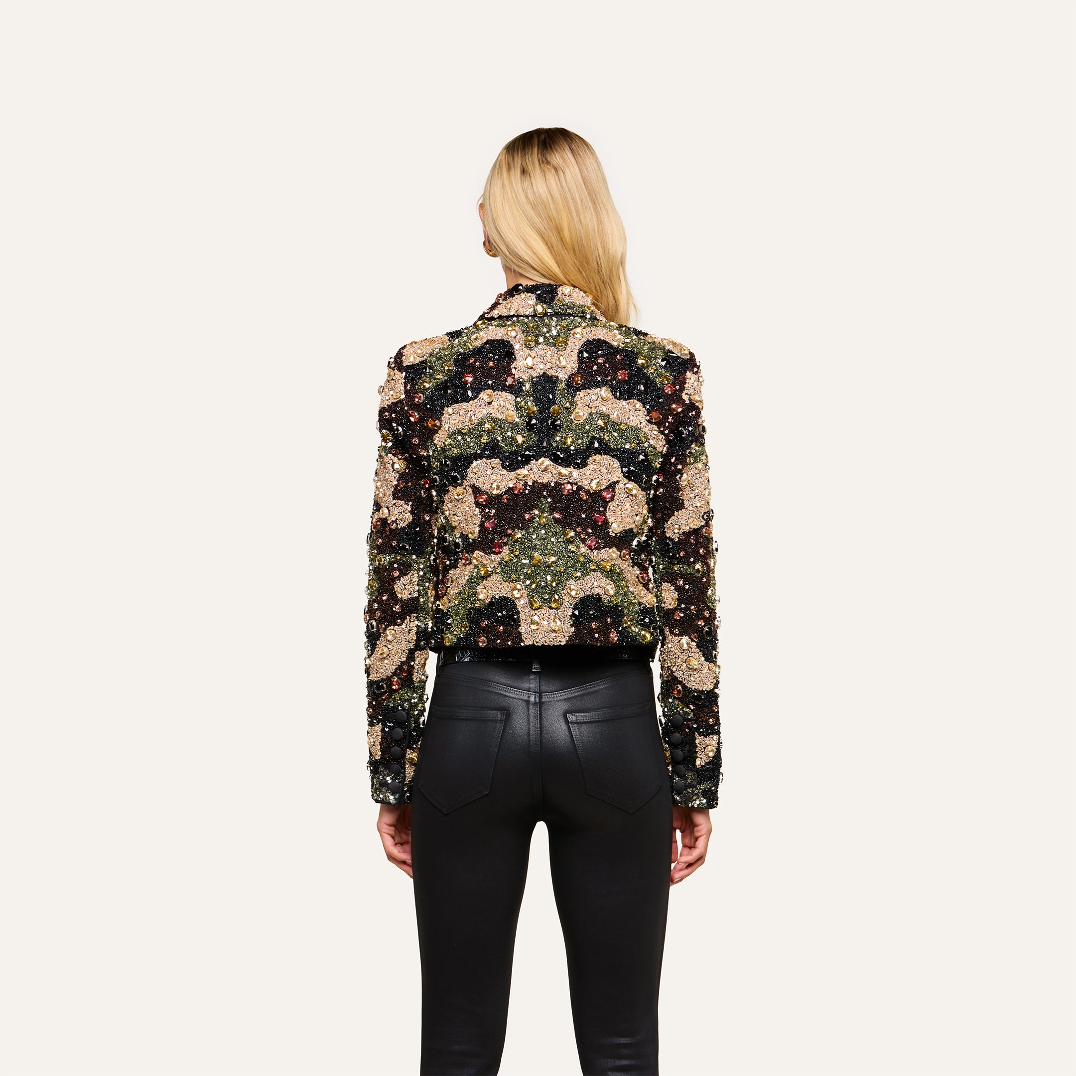 A woman with long blonde hair, seen from behind, wears the Jen Crystal Blazer and black leather pants, standing against a plain off-white background.