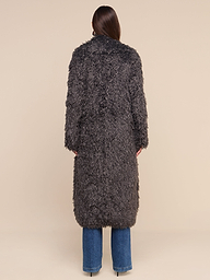 A person stands facing away, wearing the Lizbeth Faux Fur Jacket—a long, textured dark gray shag coat—paired with blue jeans against a plain white background.