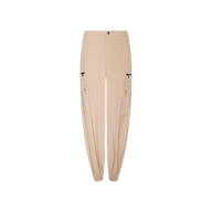 The Greer Nylon Jogger features a modern jogger silhouette in beige, complete with elastic cuffs, zippered side pockets, classic cargo pockets, and a button closure at the waist, showcased against a plain white background.