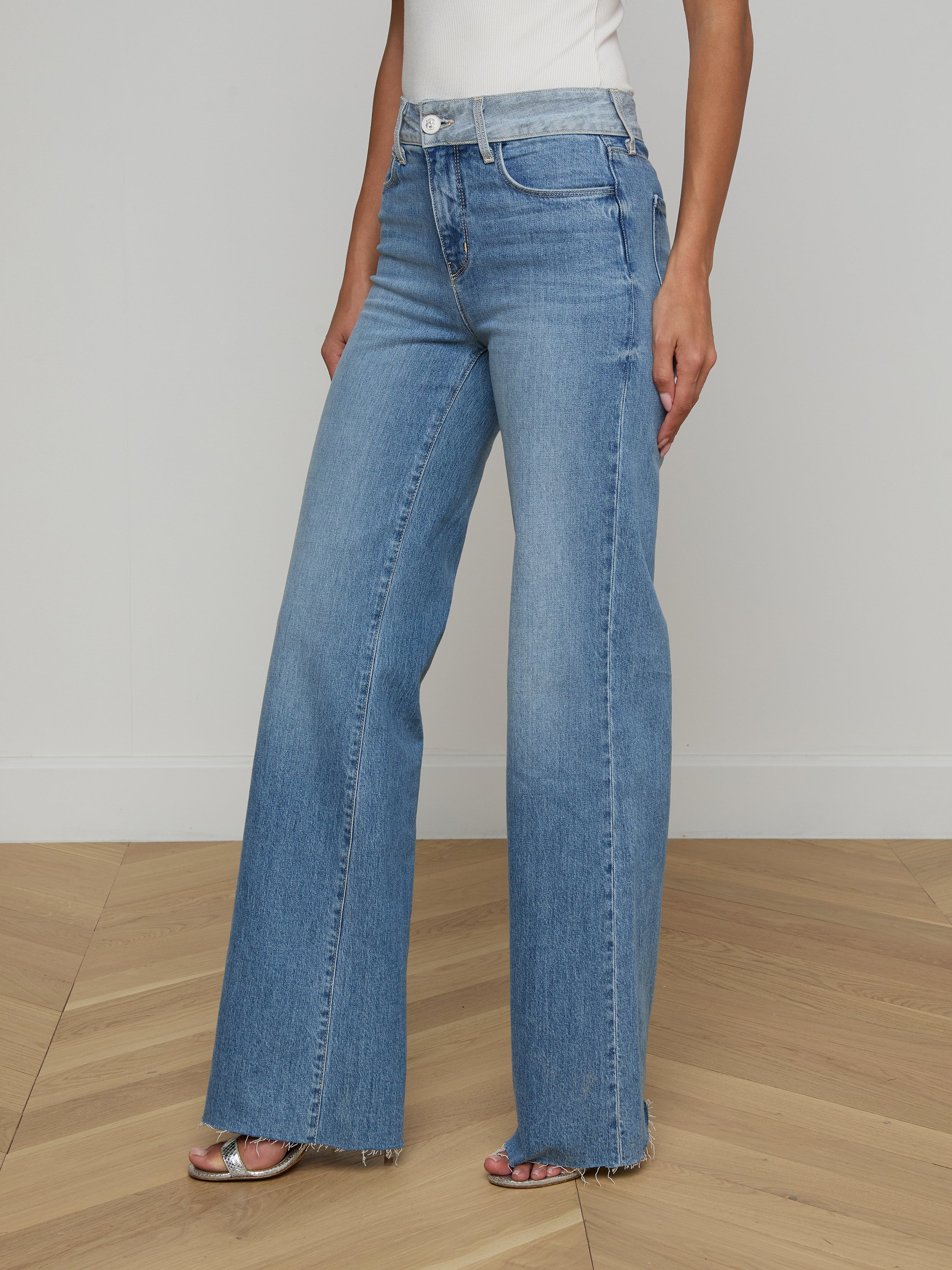 A person wearing the Louane Wide-Leg Flare Jean and a white top is standing against a plain white background.