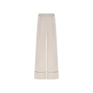 The Tavia Trouser is a wide-leg, high-waisted style crafted from cream-colored satin, featuring subtle waistband detailing and a thin dark horizontal stripe near the hem of each leg. These luxe loungewear pull-on trousers are showcased against a plain white background.