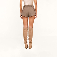 A woman stands facing away, shown from the waist down against a plain white background, wearing the Dionne Tweed Short — a high-rise brown tweed pair — styled with tall beige suede heeled boots.