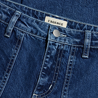 Close-up of blue denim Christel Wide-Leg Jean featuring a metal button, belt loops, visible stitching, wide-leg cut, and a white label with the brand name LAGENCE sewn on the waistband.