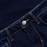 Close-up of the waistband and front pocket of dark blue denim jeans, featuring a silver button, classic belt loops, and visible white stitching for a timeless look.