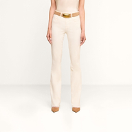 A person stands facing forward, wearing the Ruth Straight-Leg Jean in vintage white, styled with a matching cream-colored tank top, a tan belt, and brown pointed-toe shoes against a plain white background.
