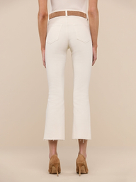 A person stands on a white background, wearing the Kendra Cropped Flare Jean in a vintage-white wash styled with a brown belt and tan high heels. The view is from behind, highlighting the back pockets and frayed hems of the jeans.