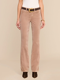 A person wearing the Stevie Velvet Jean styled in a high rise fit, paired with a white top, a brown belt, and dark brown shoes, stands against a plain white background. The image highlights the outfit from shoulders to feet.