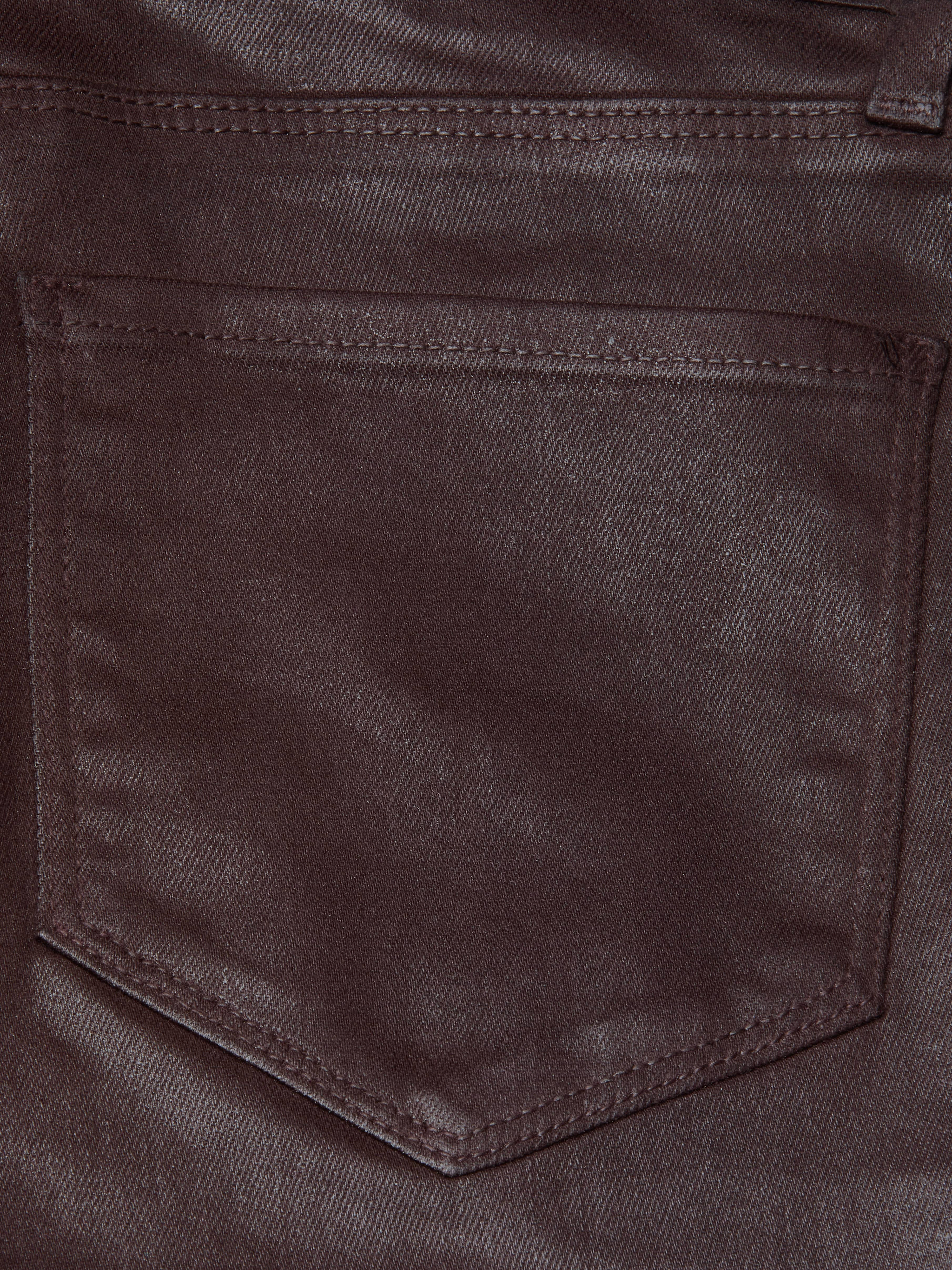 Close-up of the Selma Coated Bootcut Jean in chocolate brown denim, highlighting a stitched pocket with a pointed bottom and visible seam detailing along the edges.