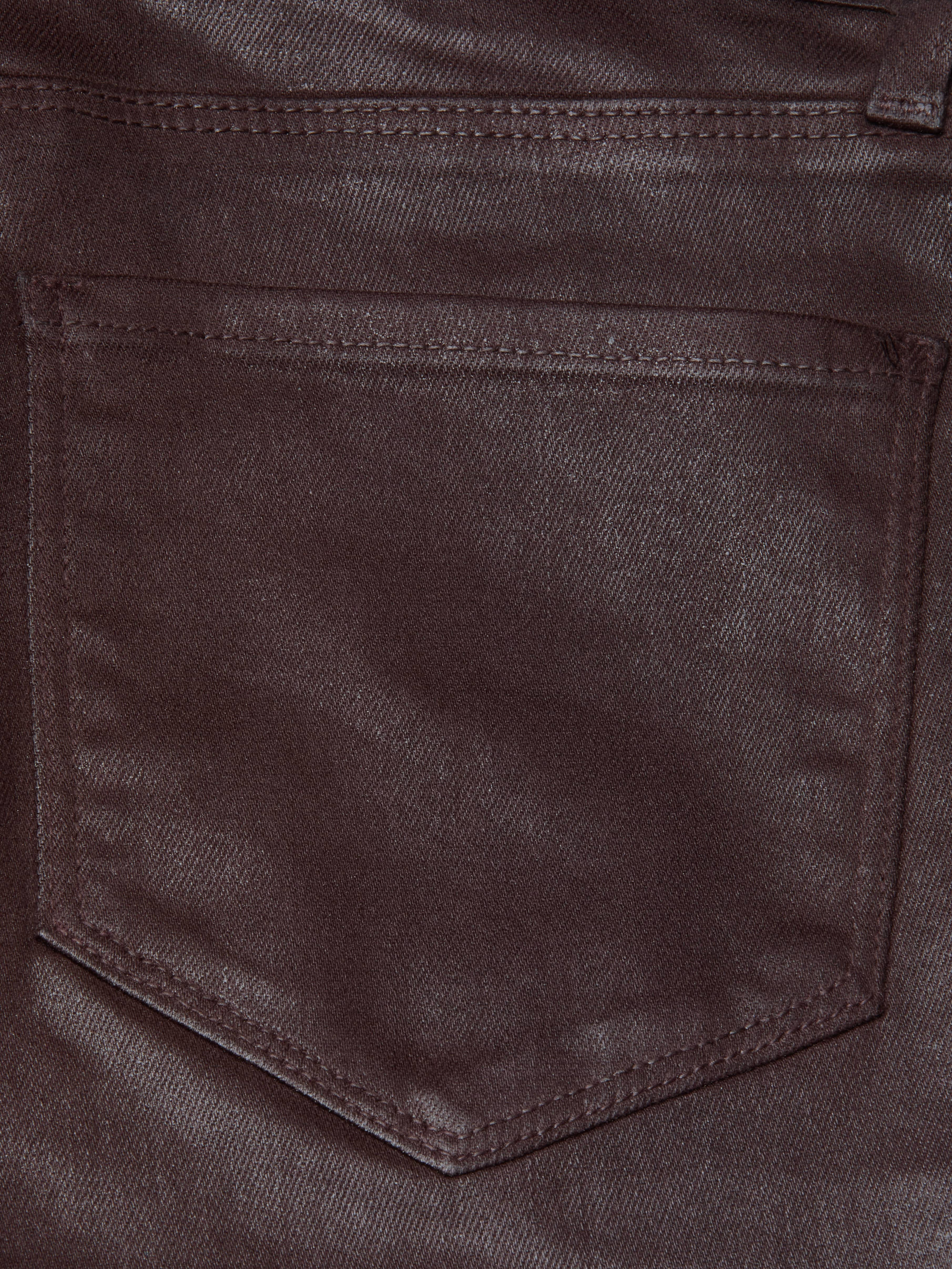 Close-up of the Selma Coated Bootcut Jean in chocolate brown denim, highlighting a stitched pocket with a pointed bottom and visible seam detailing along the edges.