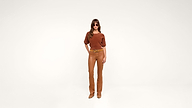A woman wearing sunglasses, a brown top, tan belt, tan pants, and tan shoes stands against a plain white background, looking confidently at the camera.