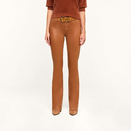 A person wearing a dark java brown sweater, the Selma Coated Bootcut Jean, and tan shoes stands against a plain white background.