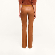 A person models the Selma Coated Bootcut Jean in a high-waisted, camel hue, paired with a dark java brown top, photographed from the back against a plain white background.