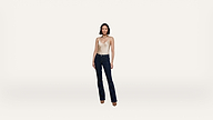 A woman stands facing forward, wearing a white sleeveless top, blue jeans, and brown shoes, against a plain white background.