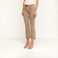 Una persona indossa i jeans Kendra Coated Cropped Flare di colore beige, abbinati a una cintura marrone e a sandali con tacco beige, in piedi davanti a uno sfondo chiaro e uniforme. È visibile solo la parte inferiore del corpo.