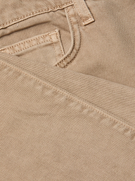 Close-up of the neutral tan denim fabric of the Wanda Cropped Wide-Leg Jean, highlighting a jeans pocket and detailed stitching, with one section of the material folded over the other.