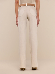 A person is shown from the back, displaying only the lower half of their body, dressed in beige Clayton Wide-Leg Jeans made from stretch denim with back pockets and a fitted waistband. The jeans are paired with a beige top and tan heeled shoes, set against a plain white background.