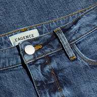 Close-up of the Clayton Wide-Leg Jean in blue denim, featuring yellow stitching, a metal button, and a white LAGENCE label near the waistband.