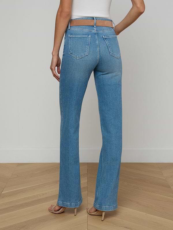 A person stands facing away, wearing the Clayton Wide-Leg Jean in light blue high-rise denim with a white top against a plain white background.
