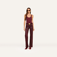 A woman wearing sunglasses, a sleeveless maroon top, the Clayton Coated Wide-Leg Jean with a contoured waistband and belt in dark maroon, and maroon heeled shoes, stands against a plain light background.