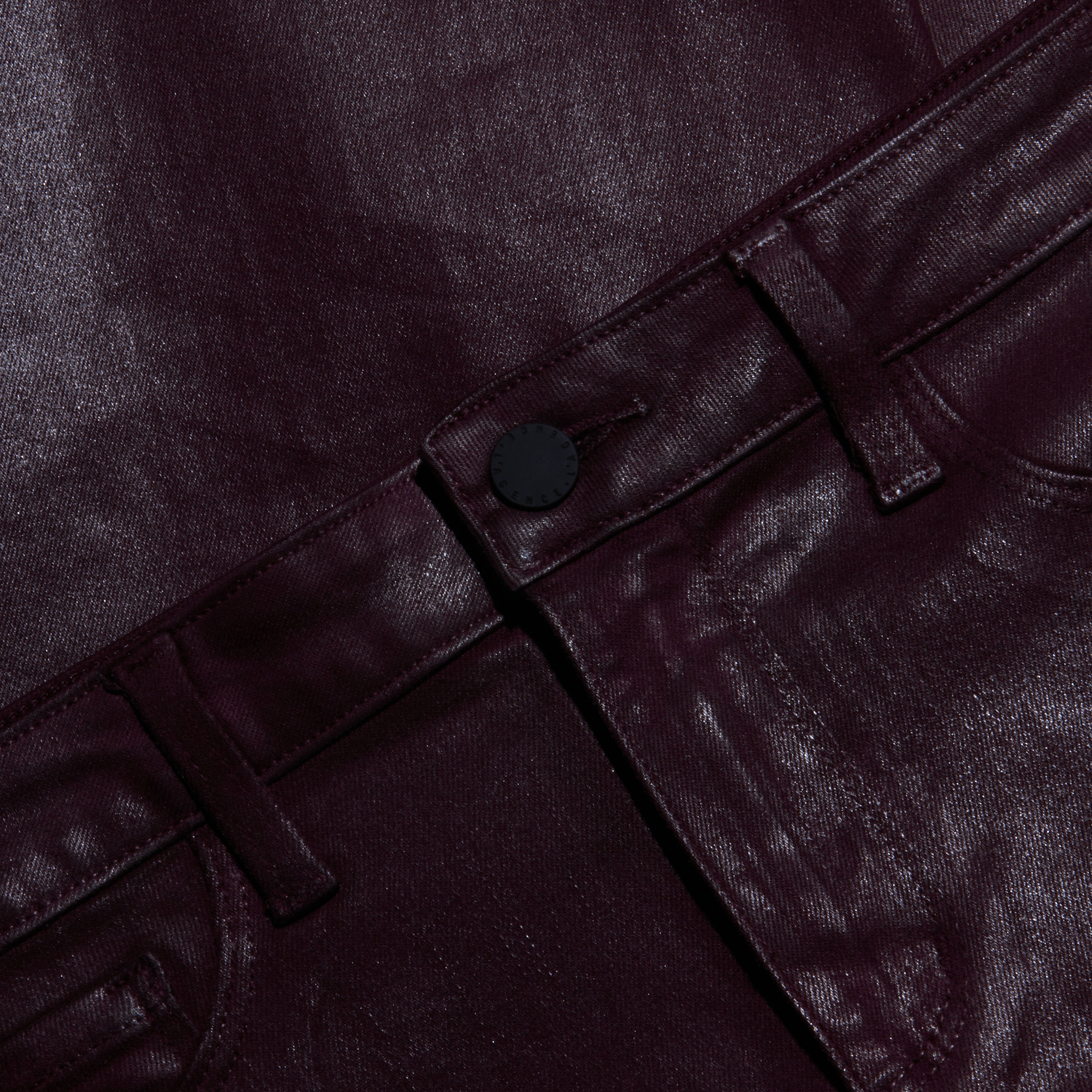 Close-up of shiny, dark burgundy metallic pants showing the waistband, belt loops, button, and part of the front pocket. The glossy fabric has a striking finish.