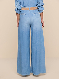 A person stands facing away, showcasing only the lower half of their body in the Lorenza Palazzo Jean against a plain white background.