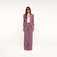 A woman stands against a plain white background wearing the Livvy Straight-Leg Trouser in mauve, paired with a light pink top and beige heels. She has long brown hair, wears sunglasses, and keeps her hands by her sides.
