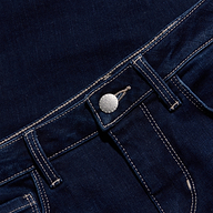 Close-up of the waistband and front pocket area of dark blue jeans with white stitching, silver button, and visible belt loops, set against a matching denim background.