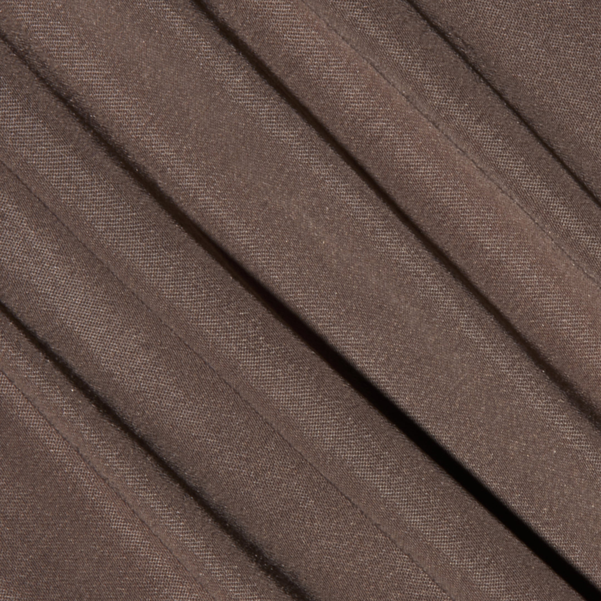 Close-up of the Palmer Satin Pant in brown, featuring diagonal pleats that highlight its soft satin texture and subtle weave pattern.