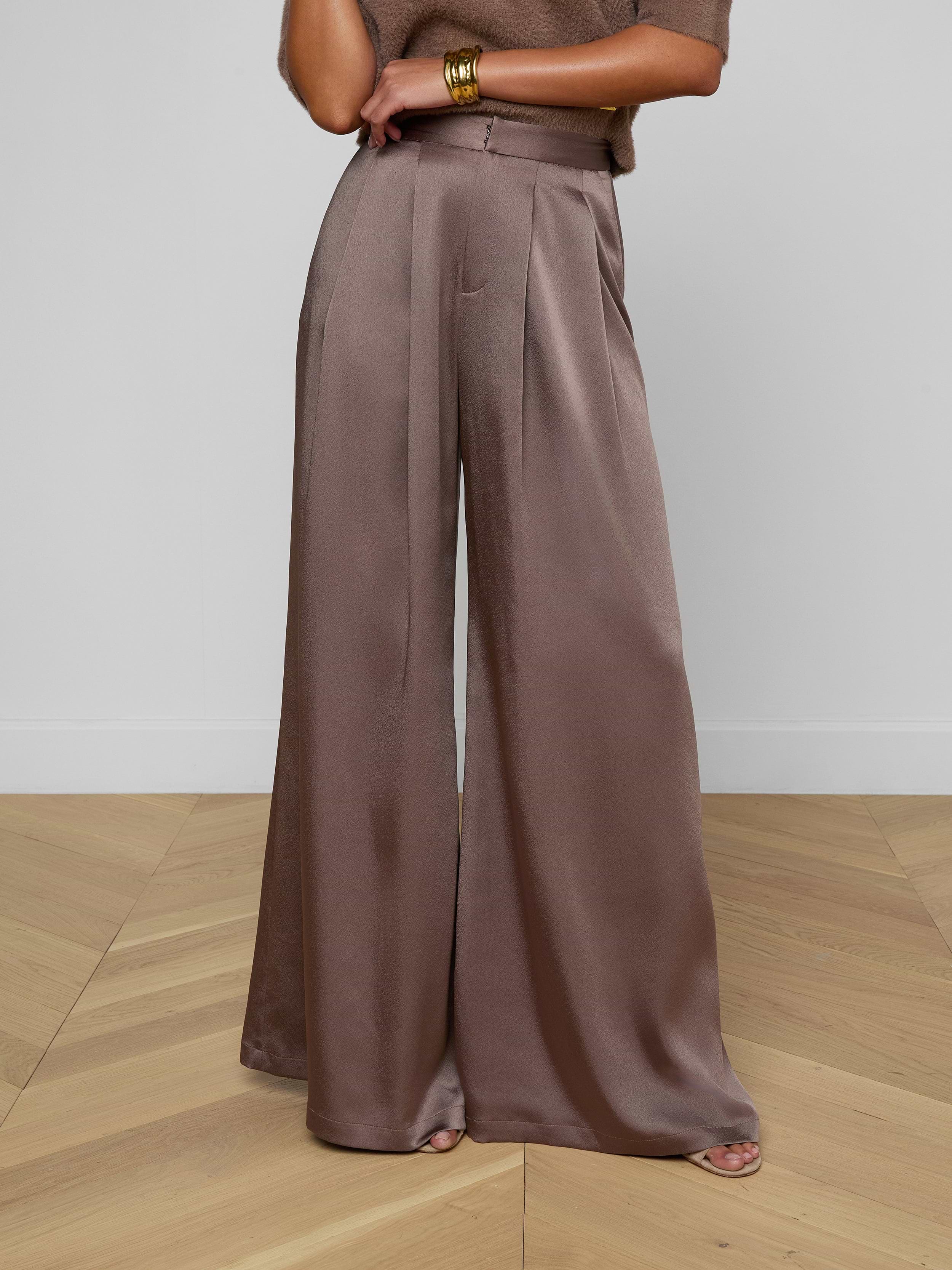 A person wearing the Aubrie Satin Pant in cardamon brown, paired with a coordinating brown top and gold bracelets on their wrist, stands against a light background.