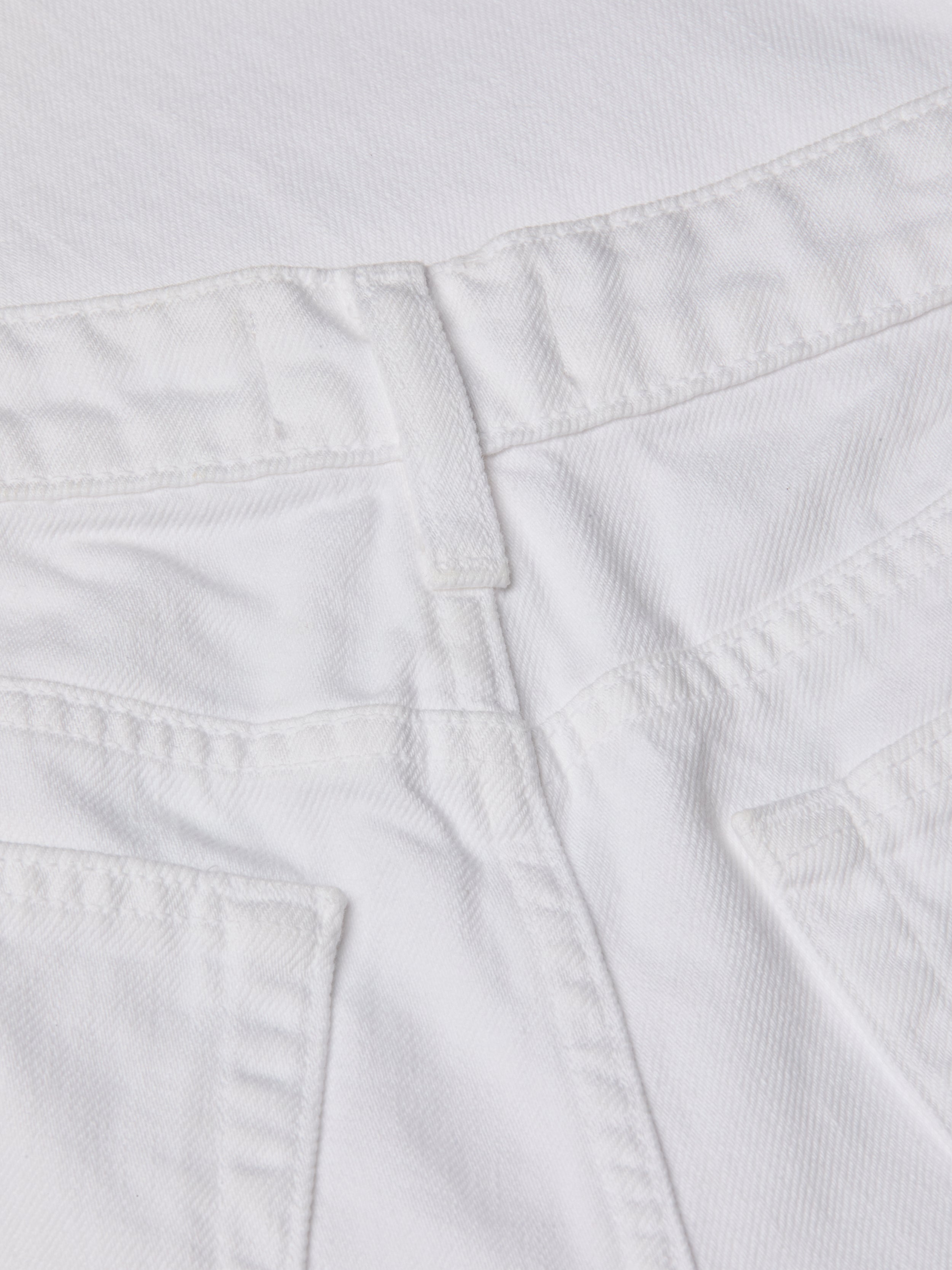 Close-up of the waistband and upper back pockets of the Joanne Low-Rise Wide-Leg Jean in white wash denim, highlighting the stitching details and belt loop.