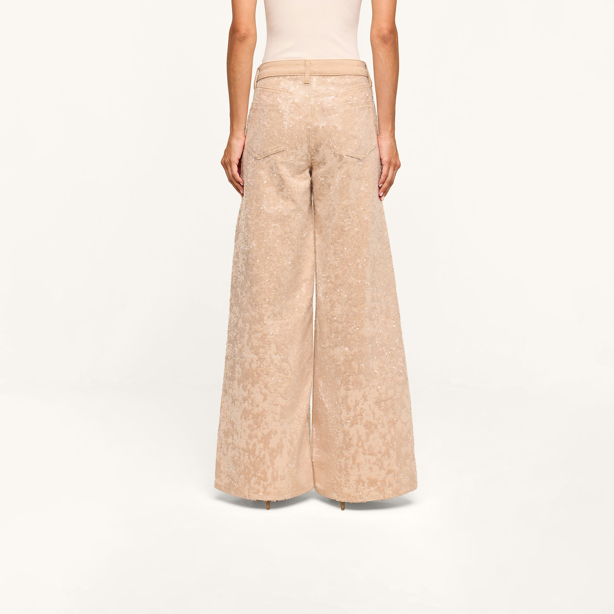A person wearing the Quincy Embellished Wide-Leg Jean and a sleeveless top, shown from the back, standing against a plain white background.