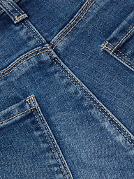 Close-up of the Cara Low-Rise Bootcut Jean in stretch denim blue, highlighting the back pockets, seams, and distinctive orange stitching. The texture and weave of the fabric are clearly visible.