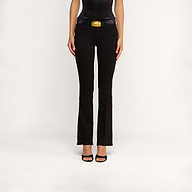 A person standing against a plain background, wearing the Cara Low-Rise Bootcut Jean in black stretch denim, paired with a black belt featuring a gold buckle and black open-toe heels. The image is cropped to show only the body from the shoulders down.
