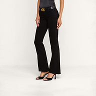 A person wearing the Cara Low-Rise Bootcut Jean in black stretch denim, paired with a black belt featuring a gold buckle, a sleeveless dark top, and black high-heeled sandals, standing against a plain white background.