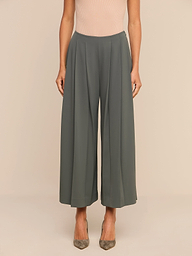 A person wearing Novalynn Cropped Pleated Pant in olive green and beige pointed-toe heels stands against a plain white background.