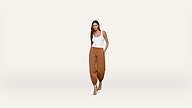 Woman wearing a white tank top and brown jogger pants with drawstring, standing and smiling with one hand in her pocket, on a plain white background.