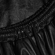Close-up of the Mariko Leather Jogger in black lambskin, featuring an elastic waistband, metal eyelets, and black drawstrings.