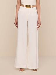 Wearing the Amara Linen Wide-Leg Pant in light beige, styled with a matching beige belt and brown open-toed shoes, the person stands against a plain white background with their upper body partially out of frame.