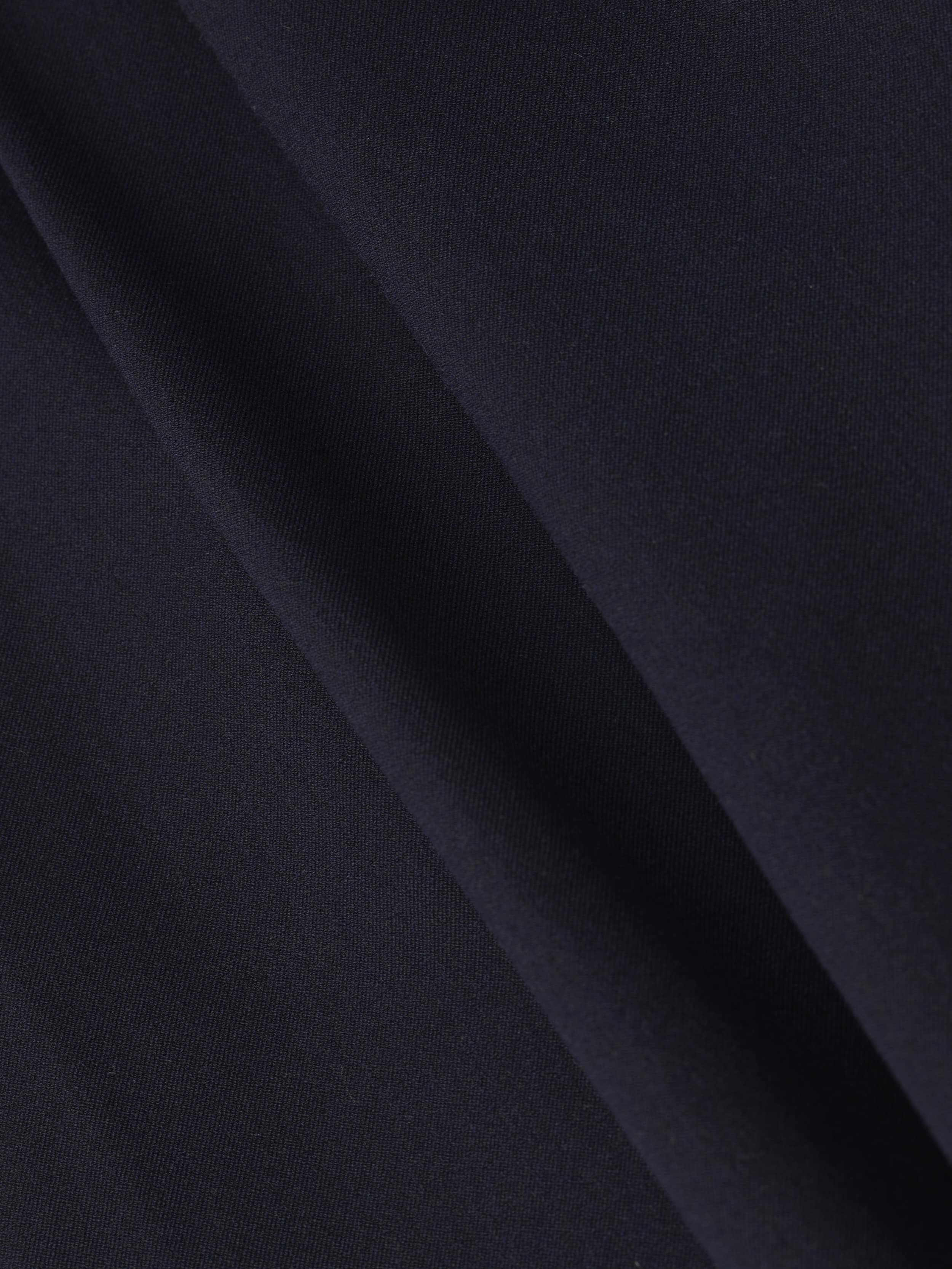 Close-up of the Chelsy Wide-Leg Pant in dark navy blue stretch fabric, featuring a diagonal crease that highlights the smooth texture and subtle folds.