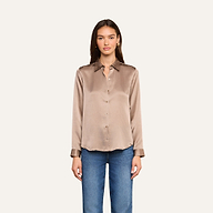 A woman stands facing forward wearing the Tyler Silk Blouse in cardamom brown, paired with blue jeans against a plain light background.