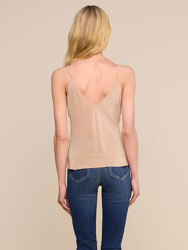 A woman with long blonde hair is standing with her back to the camera against a plain light background, wearing the Lexi Silk Camisole in blue with adjustable straps.