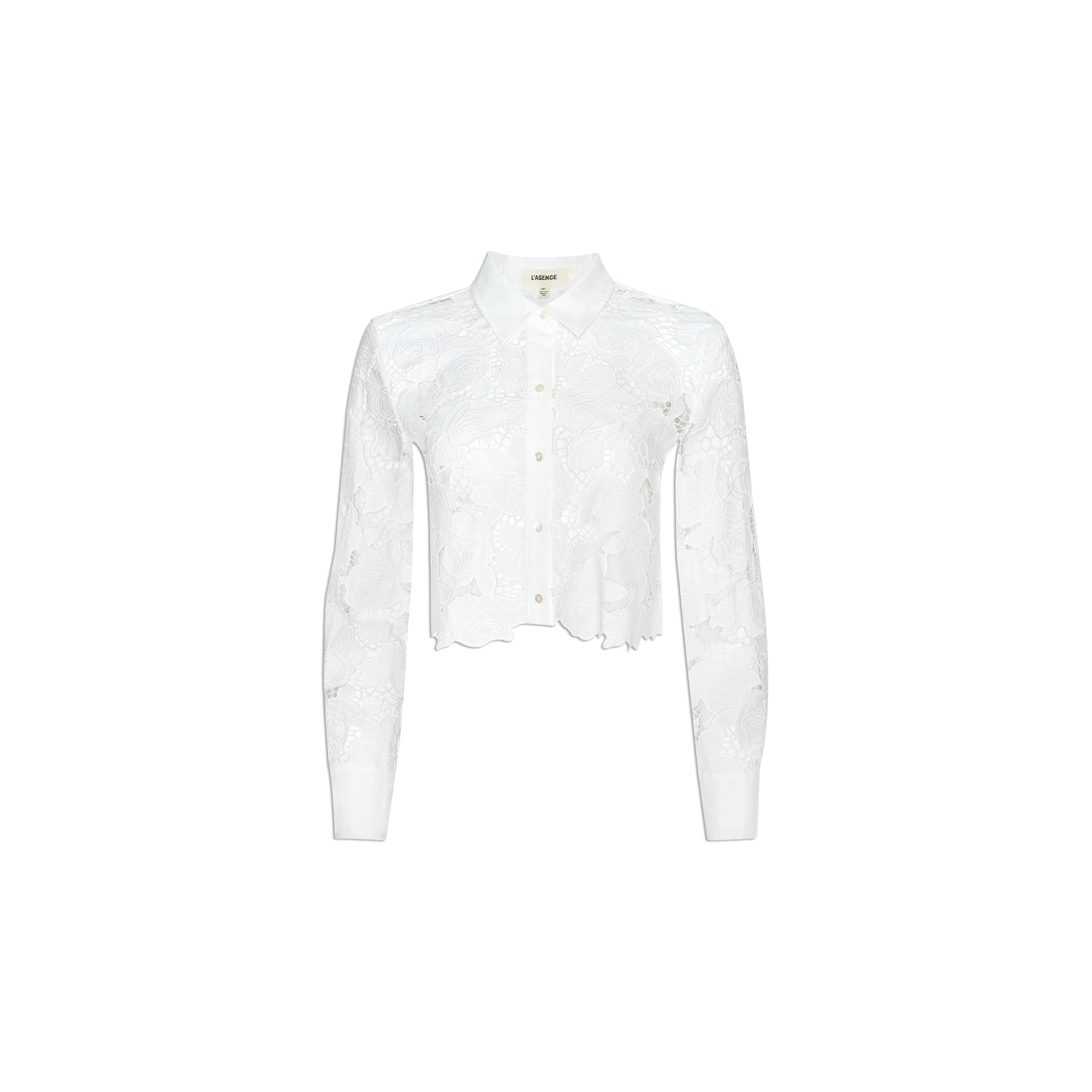 The Seychelle Cropped Eyelet Blouse is a white long-sleeve top featuring a floral lace pattern and a cropped cut hem, displayed on a plain light background.