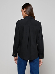 A woman with long brown hair is shown from the back against a plain light background, wearing the Ellery Button-Down Shirt in black stretch cotton and blue jeans.