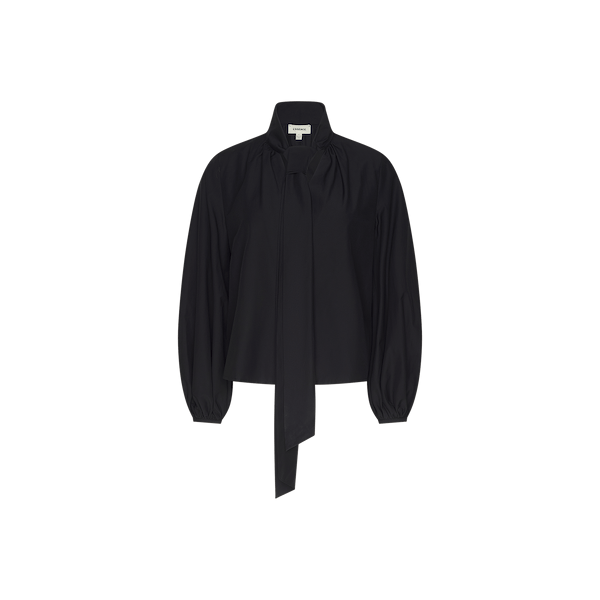 The Deon Tie-Neck Blouse is an oversized piece crafted from black organic cotton poplin, showcasing a high neck with an extended tie detail at the front, gathered shoulders, and blouson sleeves with loose cuffs, presented against a plain white background.