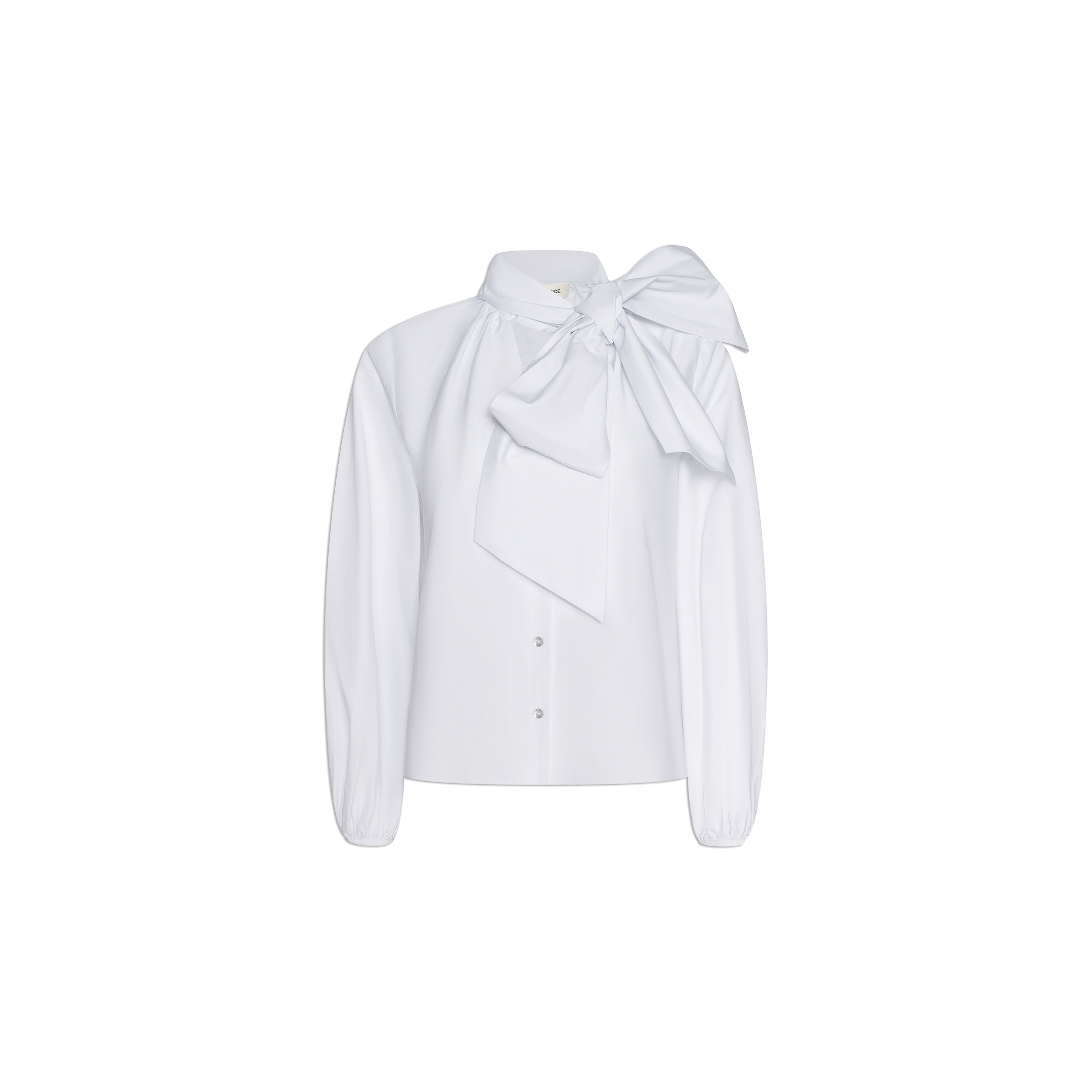 The Deon Tie-Neck Blouse is a white, long-sleeve oversized blouse crafted from organic cotton poplin, featuring a large, dramatic bow tied at the collar, elegant blouson sleeves, and a button-down front. It is displayed on a plain white background.